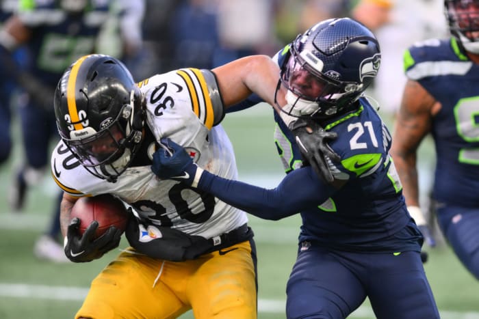 Seattle Seahawks cornerback Devon Witherspoon (21) tackles Pittsburgh Steelers running back Jaylen Warren (30) during the second half at Lumen Field.